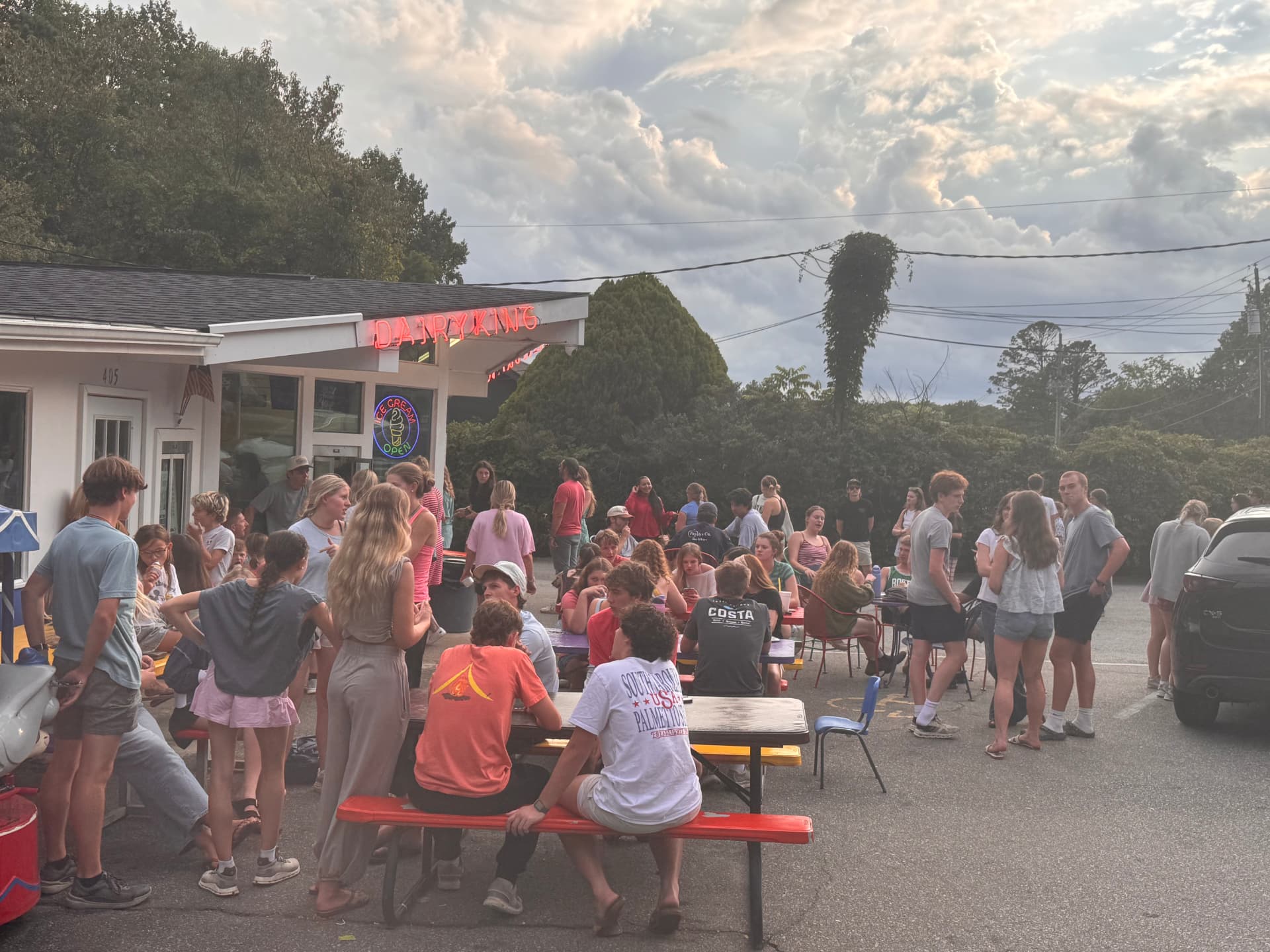 Crowd of customers gathered at the Dairy King Blue Cone stand in Black Mountain, NC at dusk