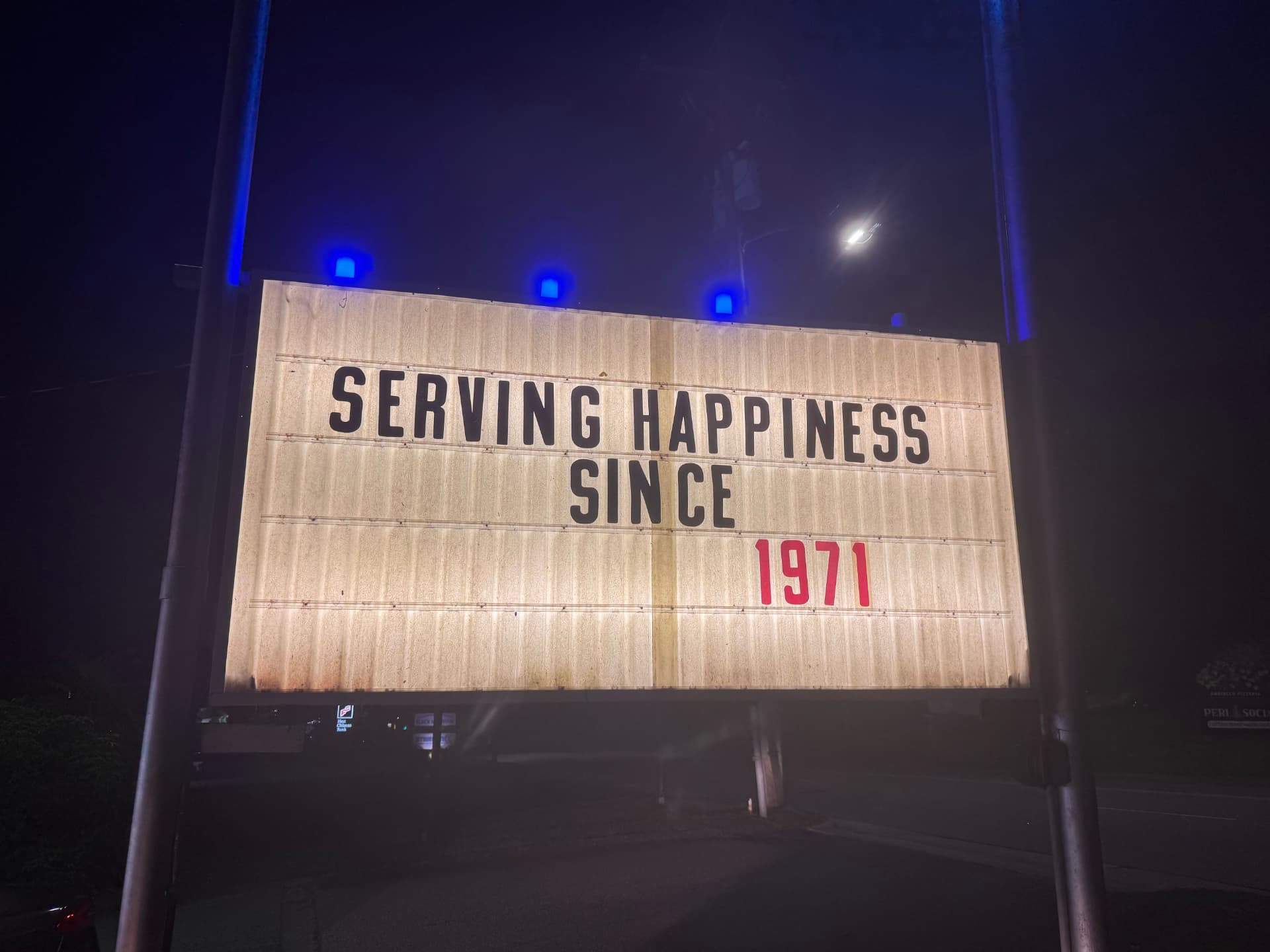 Dairy King marquee sign at night reading "Serving happiness since 1971"